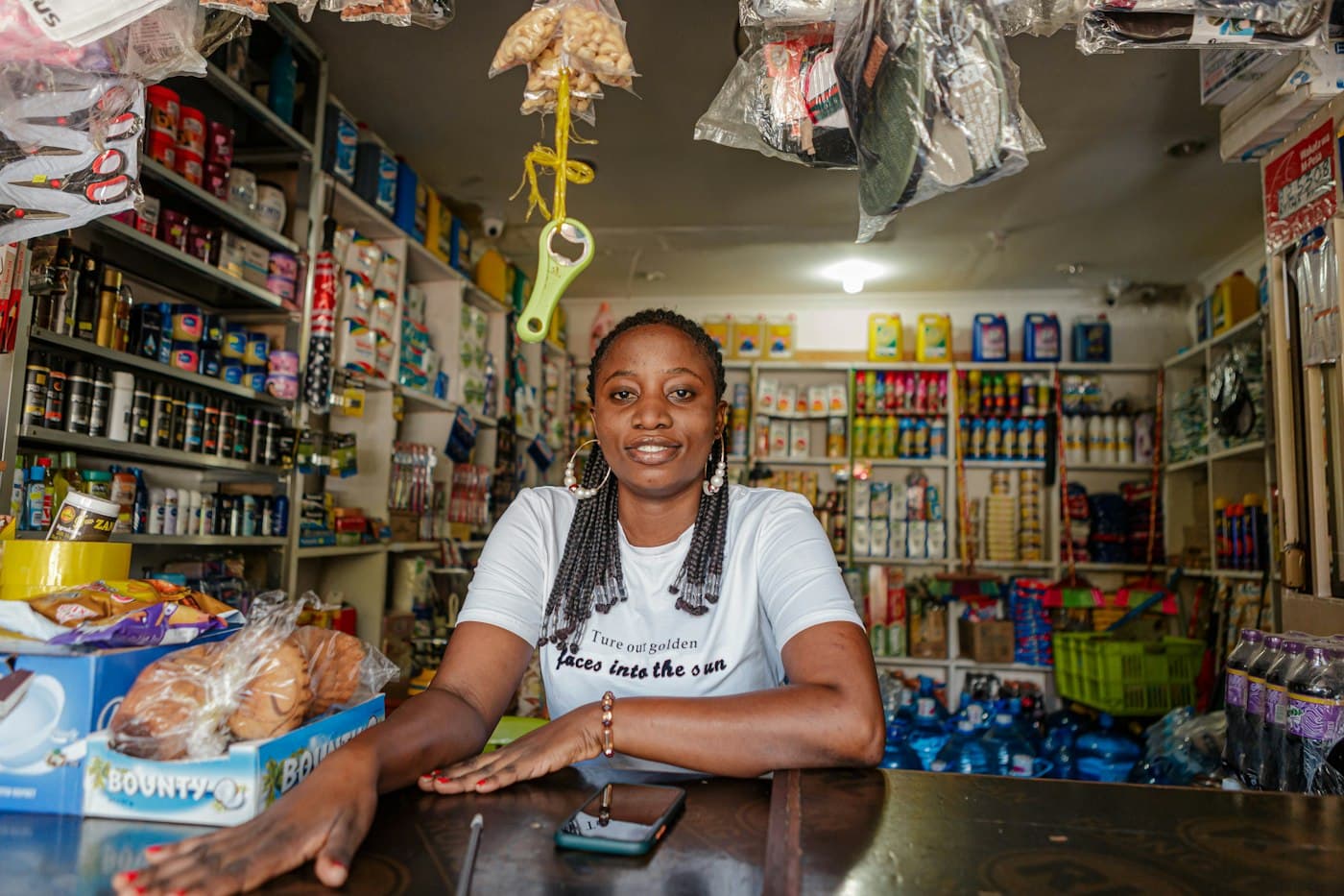 Shop owner at her counter surrounded by stock